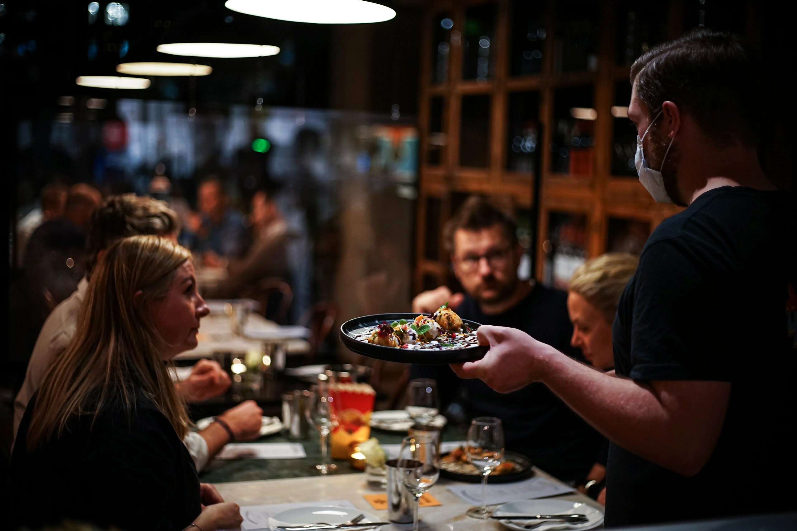 En server presenterer en tallerken chaat i den varme spisesalen